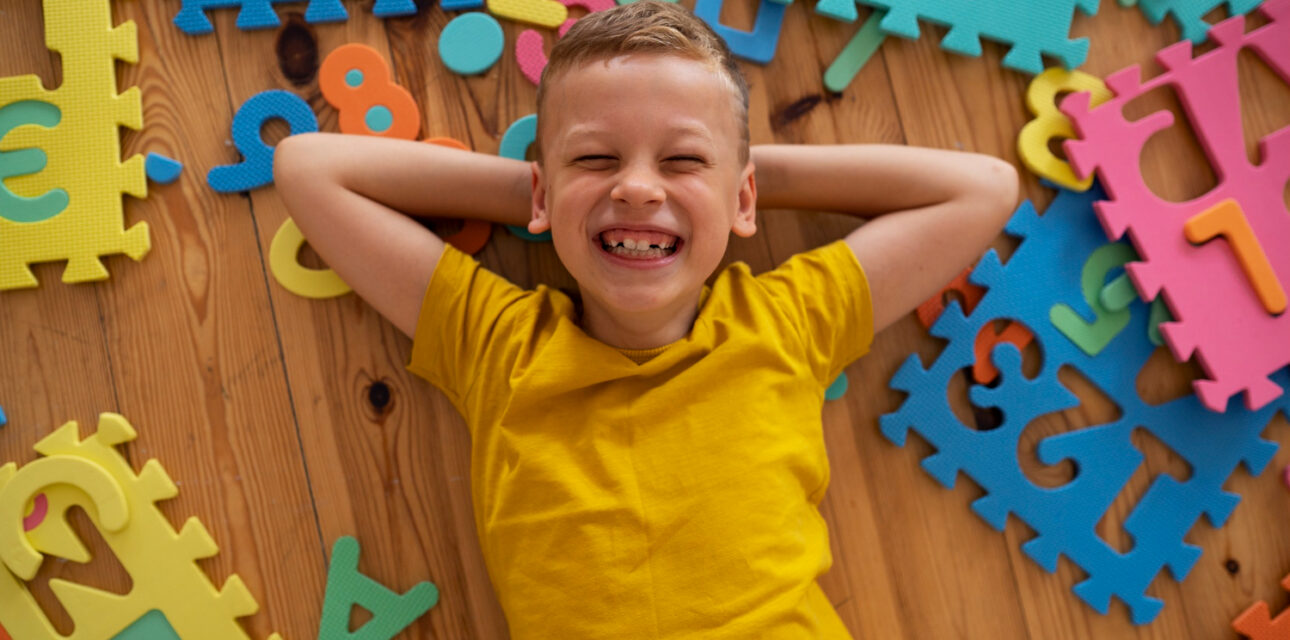 Happy child with alphabet puzzle pieces.