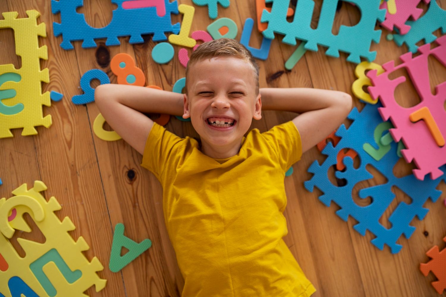 Happy child with alphabet puzzle pieces.