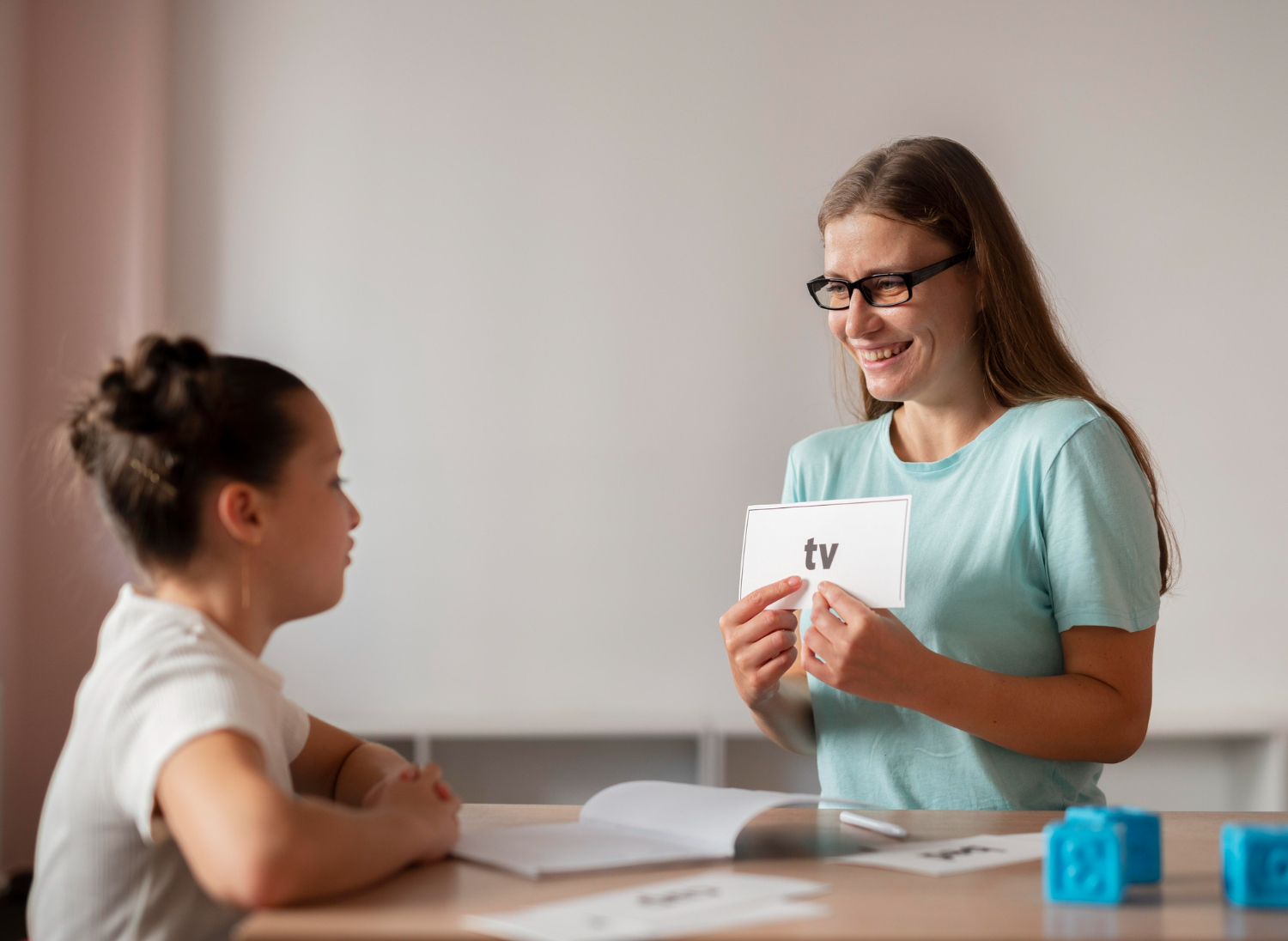 BCBA using a flashcard with a child in home-based ABA therapy.