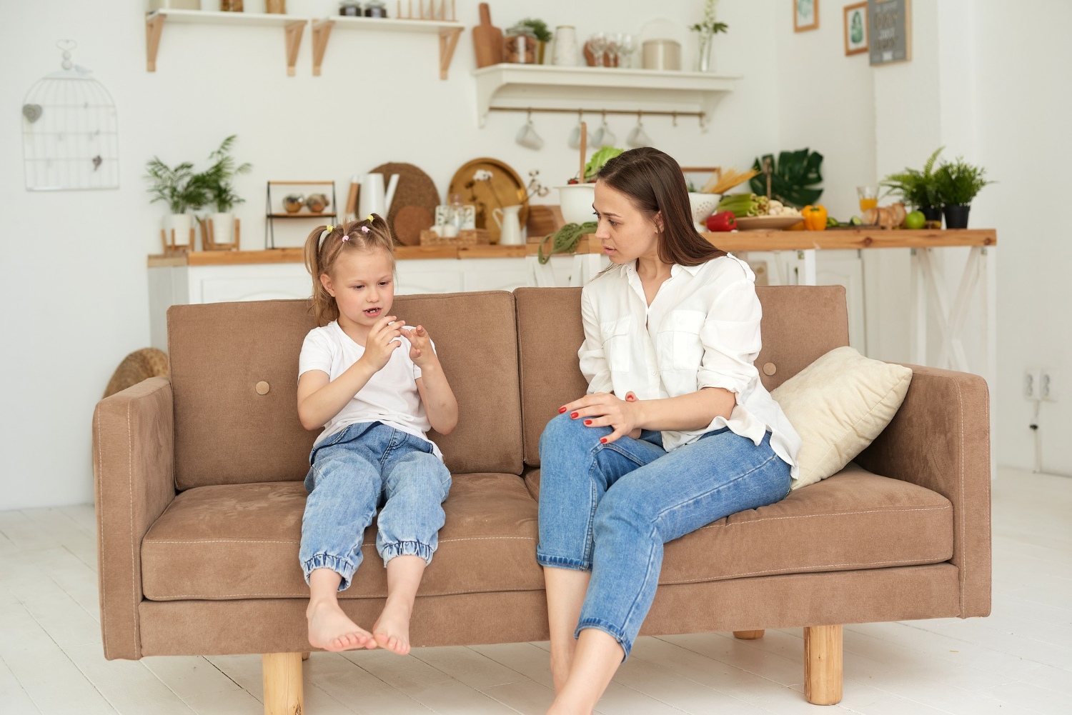 Adult sitting with a child during an in-home ABA therapy session on a living room couch.
