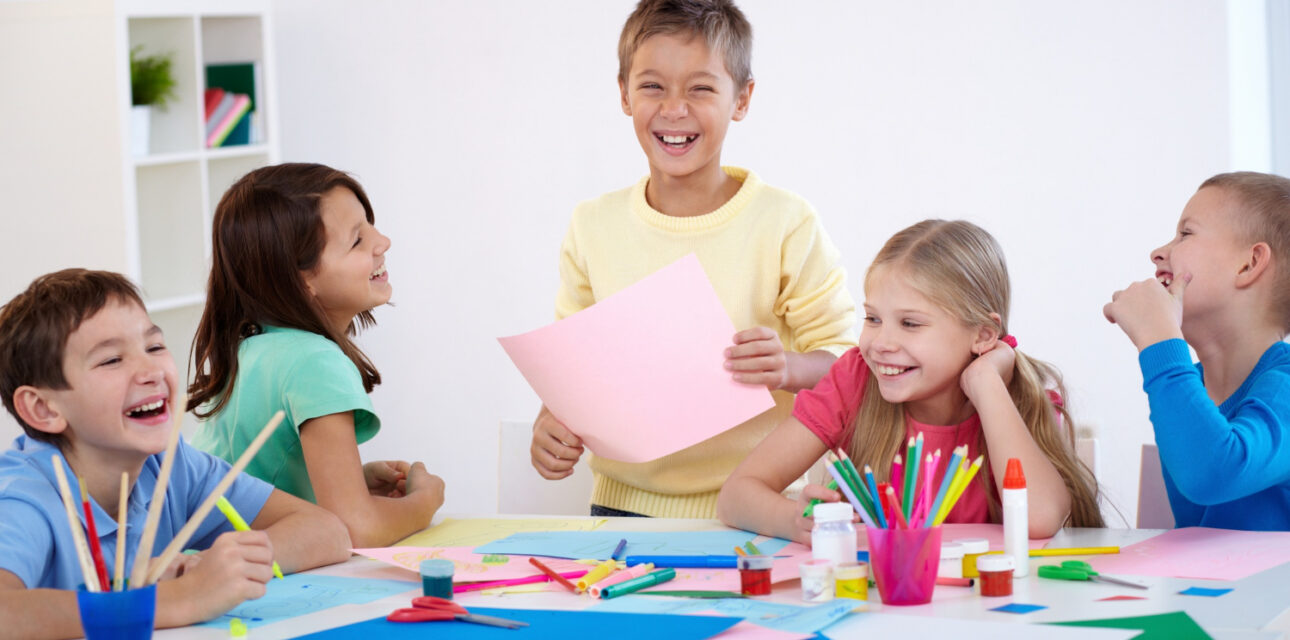Children laughing together during an arts and crafts activity.