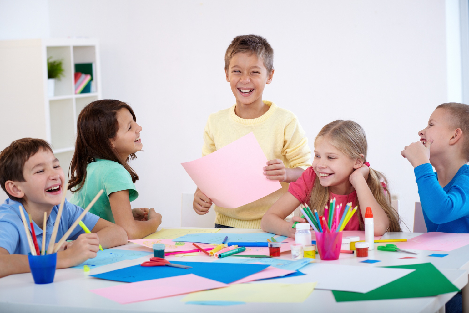 Children laughing together during an arts and crafts activity.