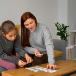 BCBA supporting a child with autism using picture cards during ABA therapy.