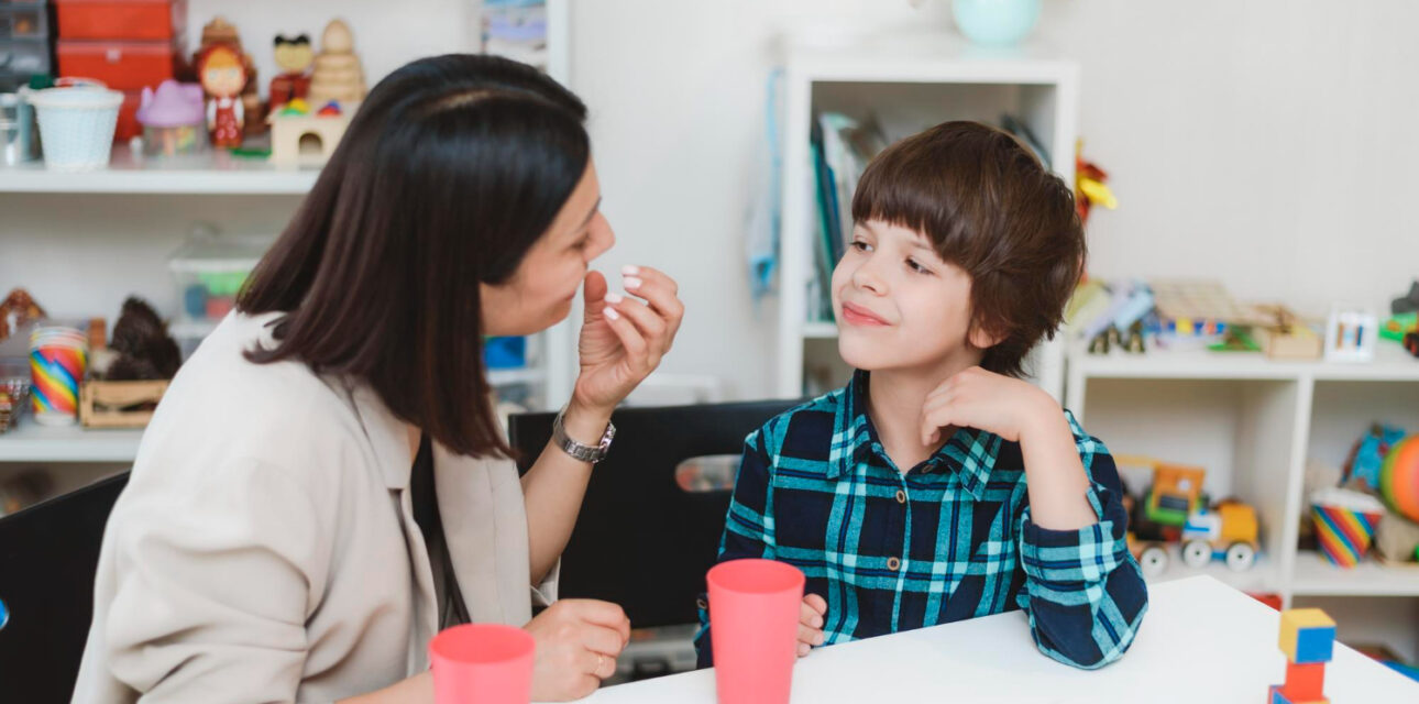 Therapist using ABA prompting with a child during a learning activity.