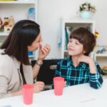 Therapist using ABA prompting with a child during a learning activity.