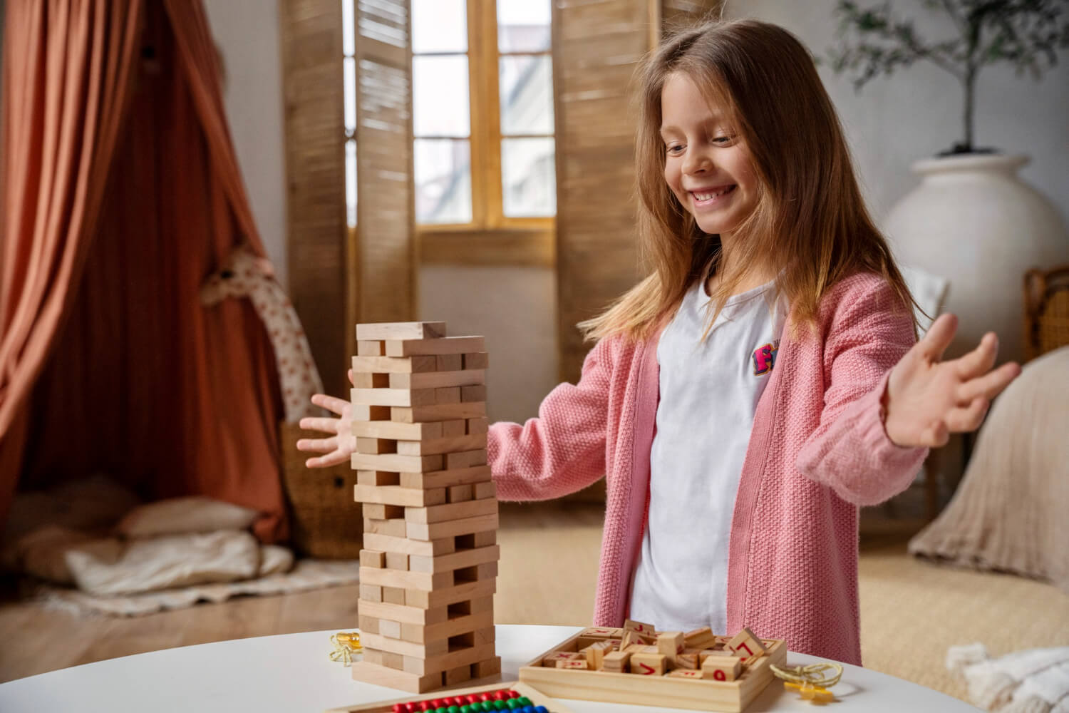 Girl with autism playing with wooden blocks during an ABA therapy activity at home.