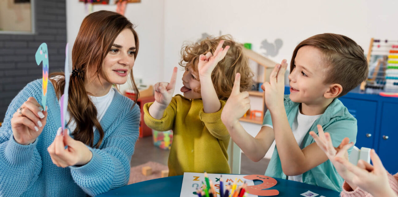 BCBA leading a hand-sign activity in an autism-friendly daycare.