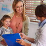 Mother and child speaking with a clinician during an autism assessment or ABA therapy consultation.