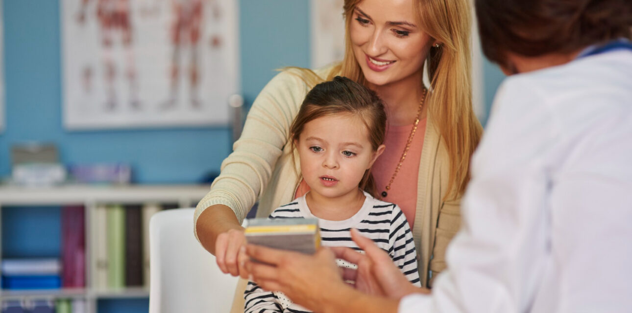 Mother and young child discussing an autism diagnosis with a healthcare professional.