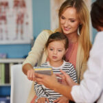 Mother and young child discussing an autism diagnosis with a healthcare professional.