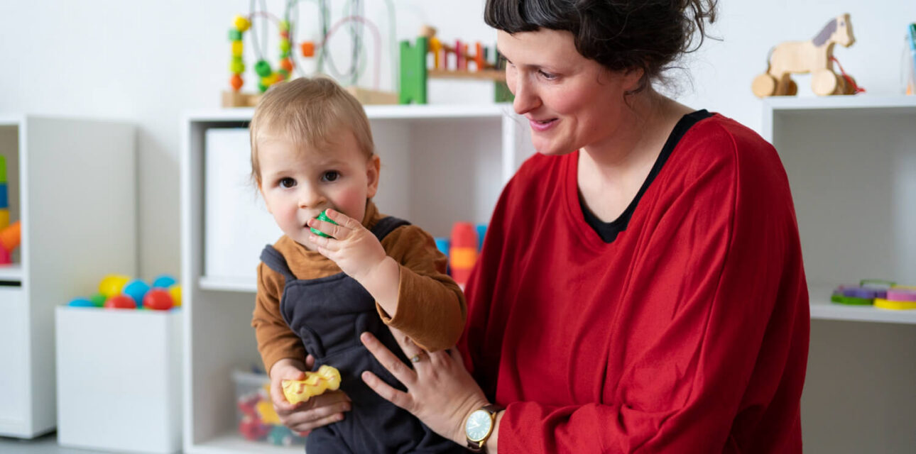 BCBA supporting a young child with autism during ABA therapy.