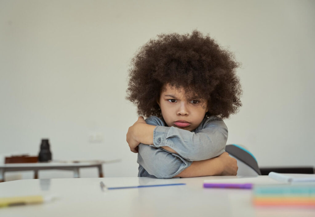 Autistic child experiencing an after-school meltdown while sitting at a table.