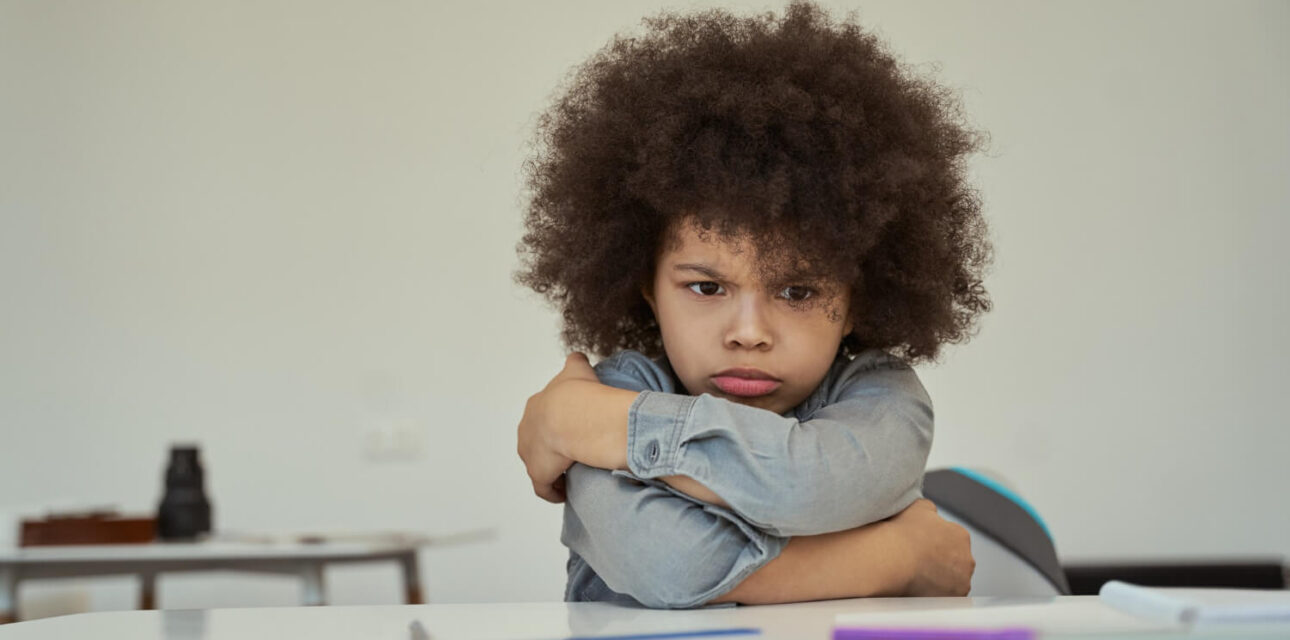 Autistic child experiencing an after-school meltdown while sitting at a table.