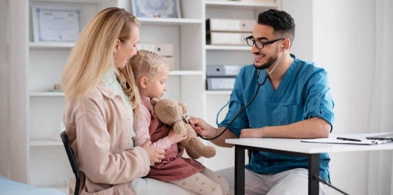 Doctor examining a young autistic child with a stethoscope during a pediatric visit.
