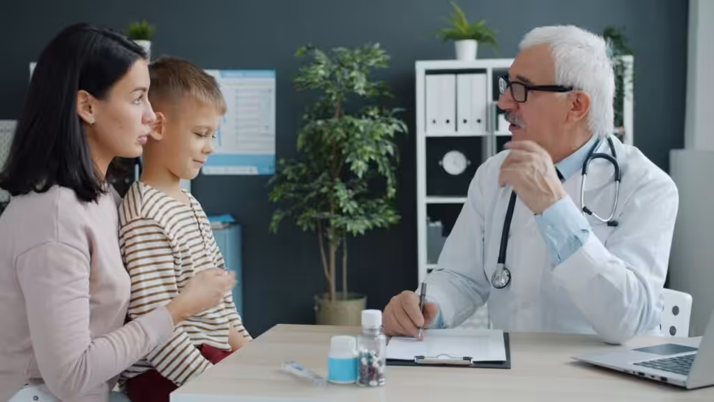 Doctor discussing an autism evaluation with a mother and her young child during a consultation.