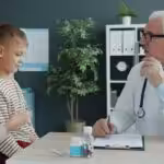 Doctor discussing an autism evaluation with a mother and her young child during a consultation.