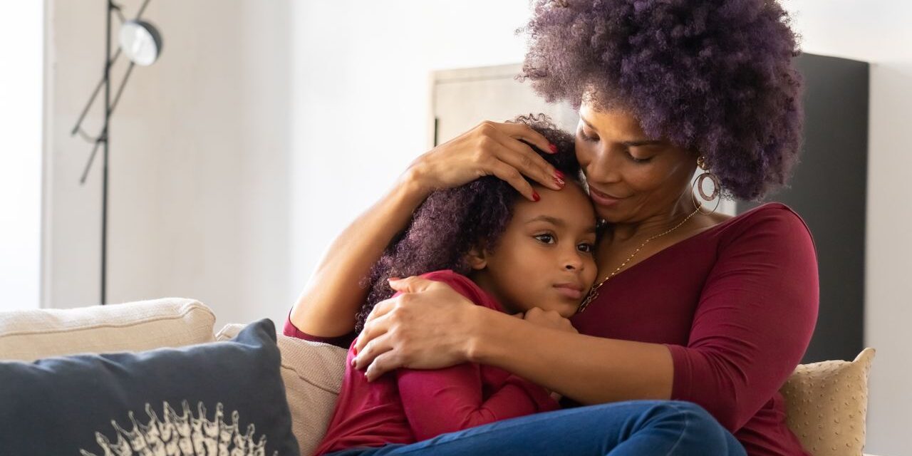 Mother comforting her autistic daughter at home with support from BCBA-led ABA therapy.