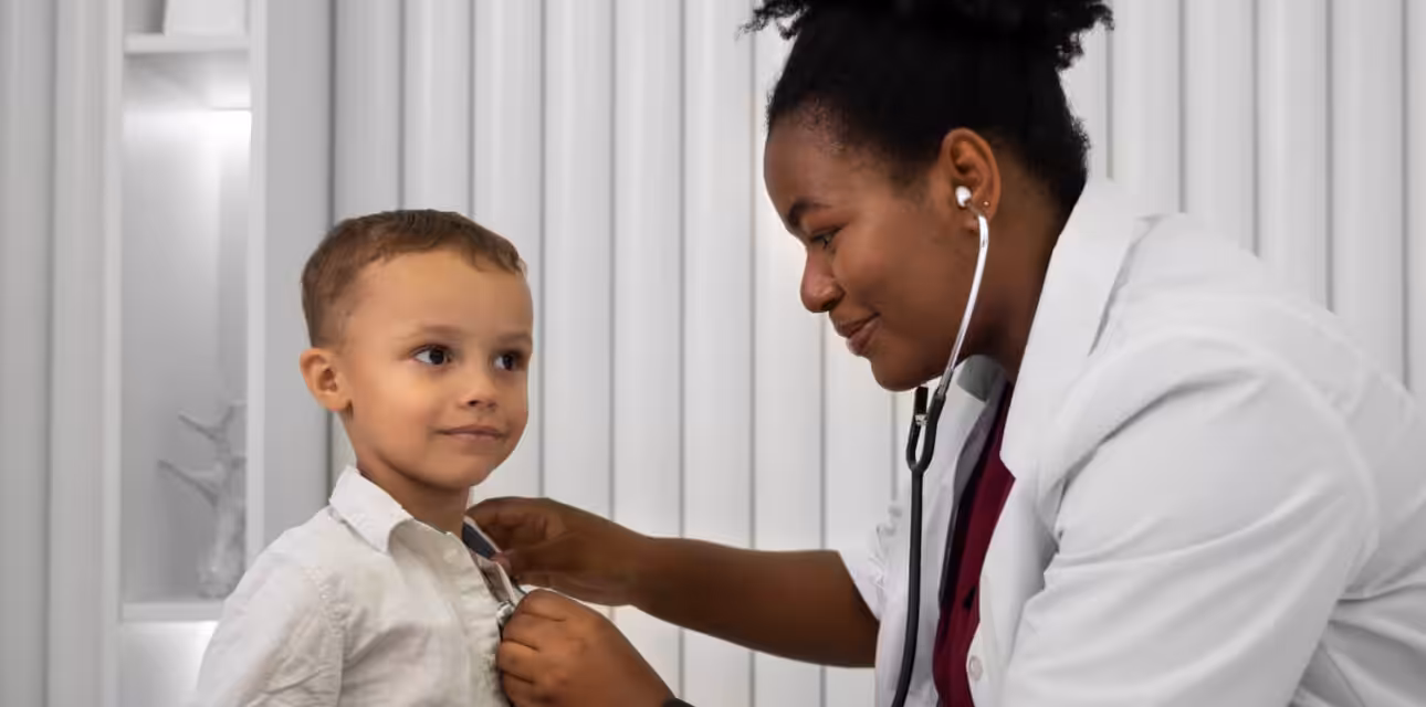 Doctor examining a young child with a stethoscope during a pediatric visit for an autism evaluation.